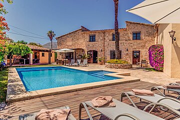 A large swimming pool is surrounded by chairs and umbrellas
