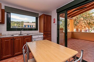 A kitchen with a sliding glass door leading to a balcony