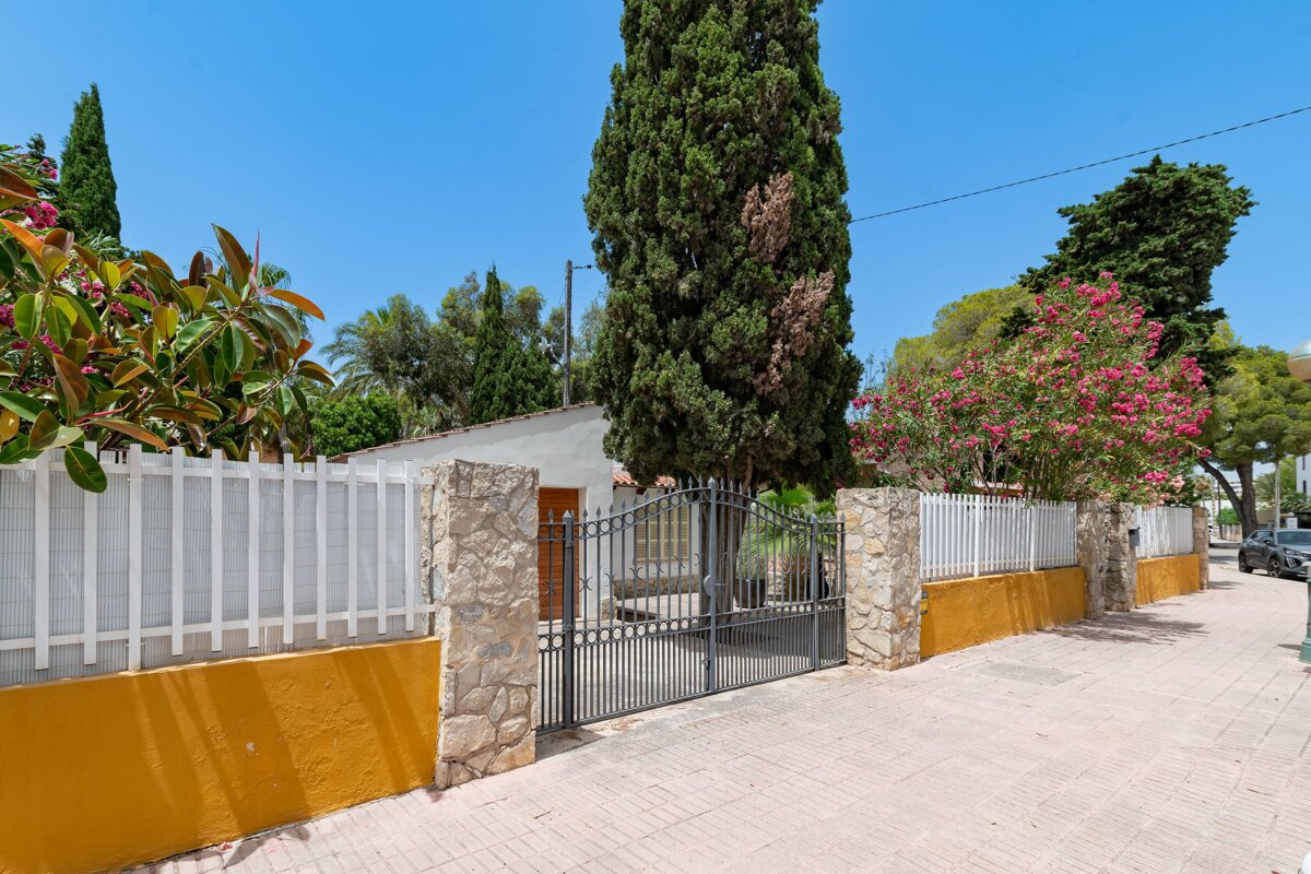 A house with a fence and a gate in front of it
