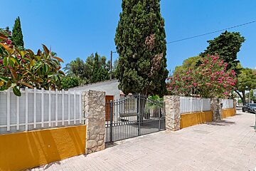 A house with a fence and a gate in front of it