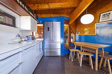 A kitchen with a stainless steel refrigerator and a table