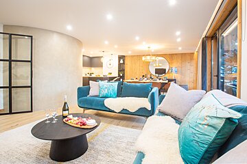 A living room with a blue couch and a black coffee table