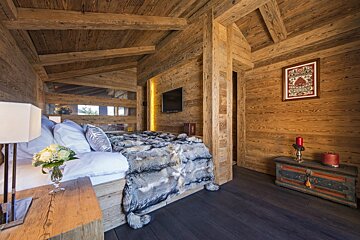 A wooden room with a bed and a picture on the wall