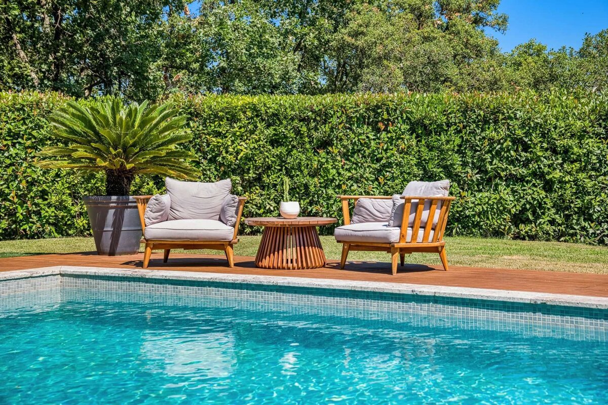 Two chairs and a table next to a swimming pool