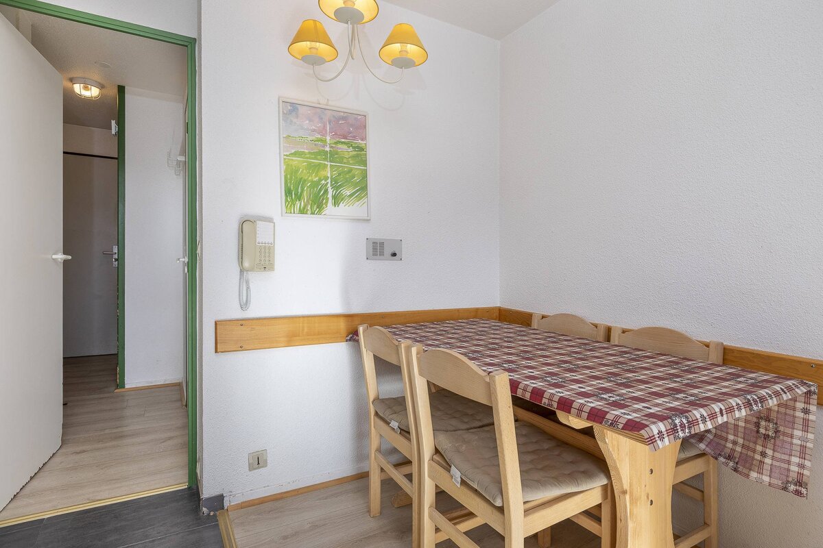 A room with a table and chairs and a phone on the wall