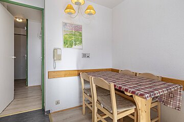 A room with a table and chairs and a phone on the wall