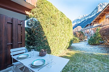A table with plates and glasses on it with mountains in the background