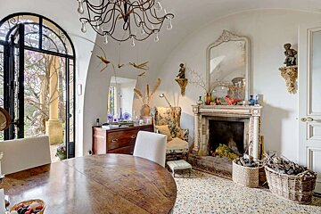 A dining room with a table and chairs and a fireplace