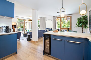 A kitchen with blue cabinets and a wine cooler