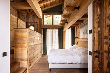 A bedroom with wooden walls and a large bed