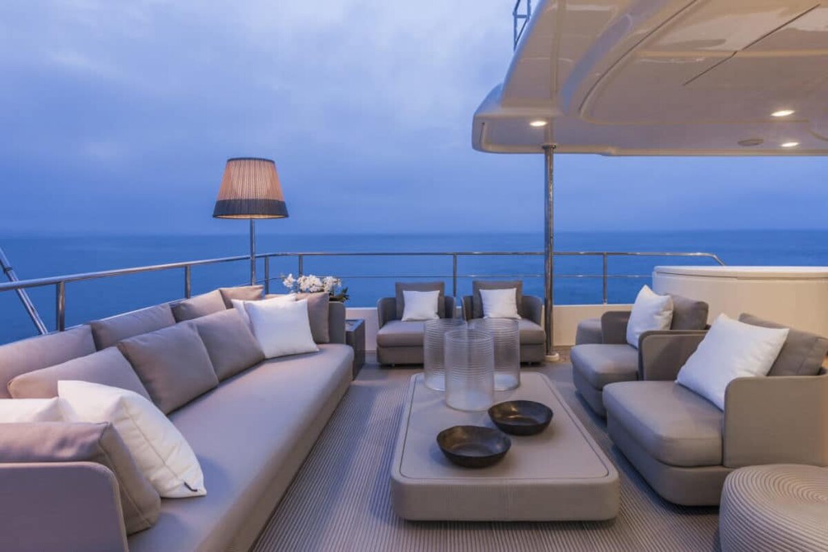 A couch and chairs on a deck overlooking the ocean