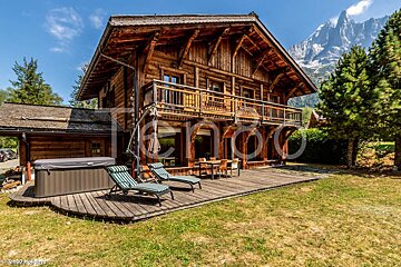 A large wooden house with a hot tub in front of it