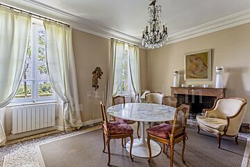 A dining room with a marble table and chairs