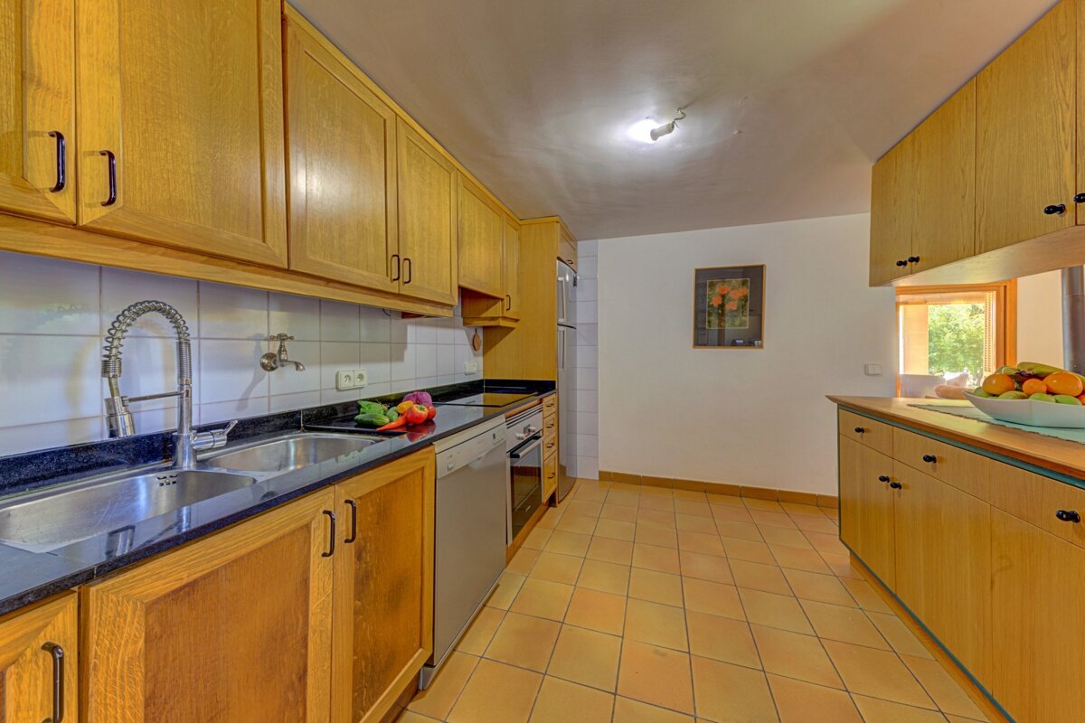 A kitchen with a bowl of fruit on the counter