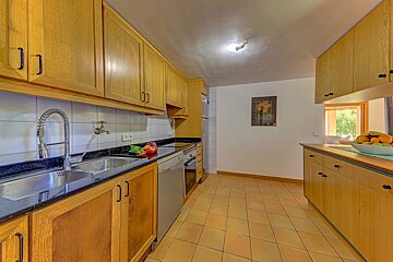 A kitchen with a bowl of fruit on the counter