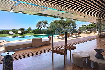 A living room with a swimming pool in the background
