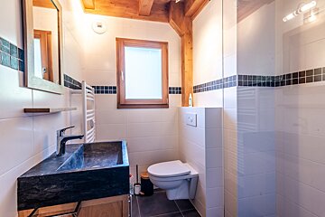 A bathroom with a toilet a sink and a window