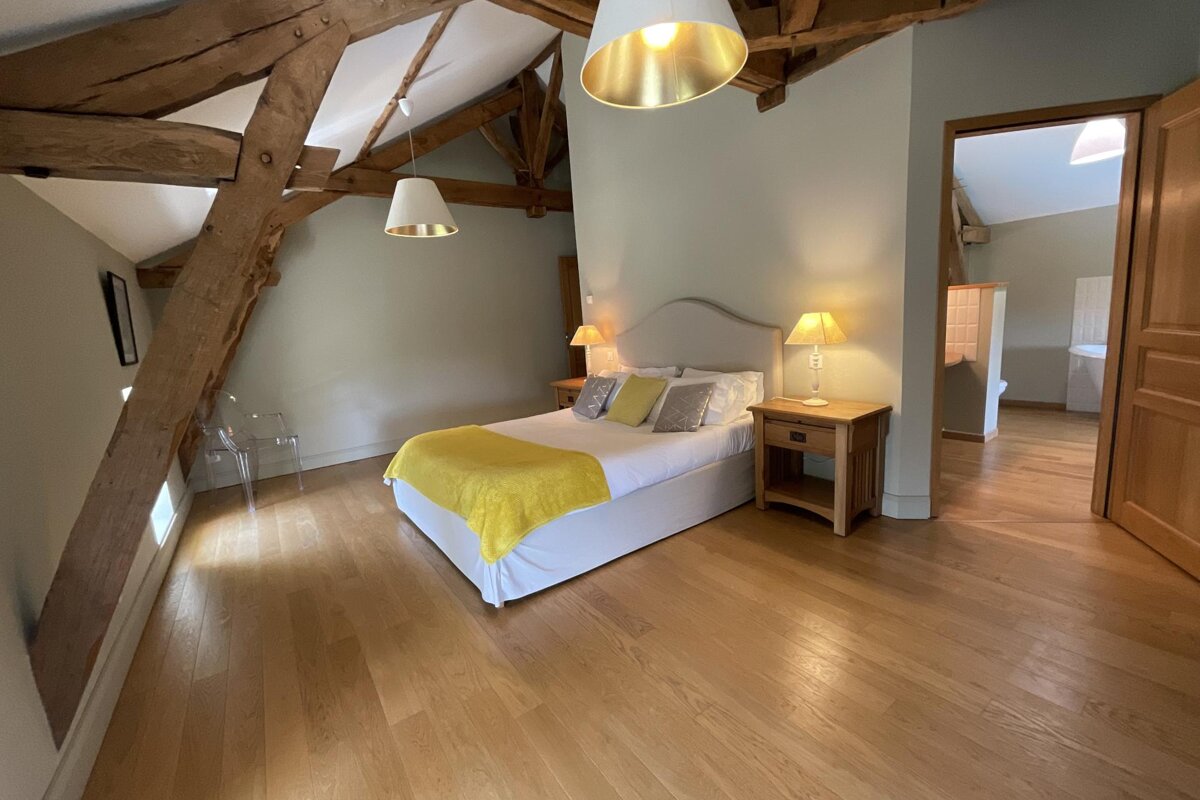 A bedroom with a yellow blanket on the bed