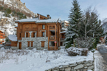A snow covered building with a red sign that says danger