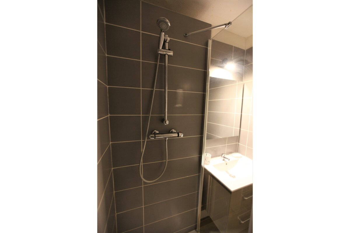 A bathroom with a shower head and a sink