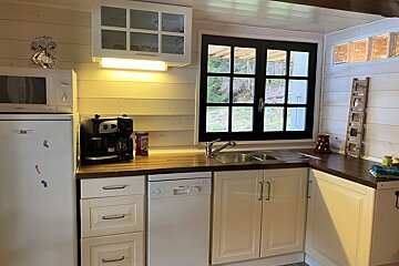 A kitchen with white cabinets and a bosch refrigerator