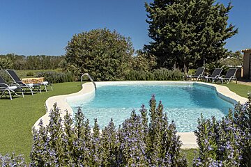 A large swimming pool surrounded by chairs and flowers