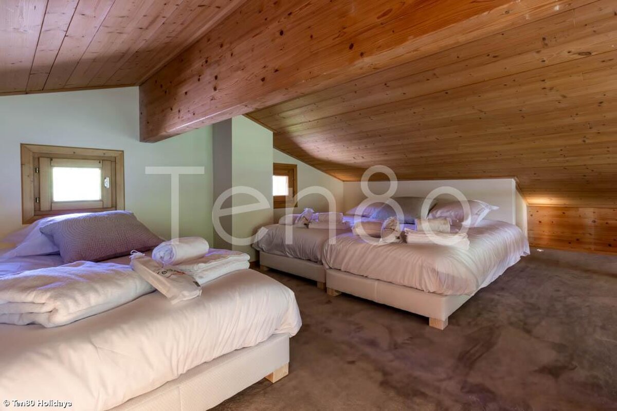 A bedroom with two beds and a sign that says ten80