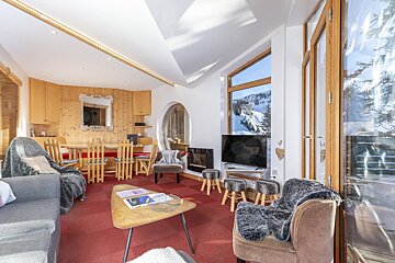 A living room with a table and chairs and a fireplace