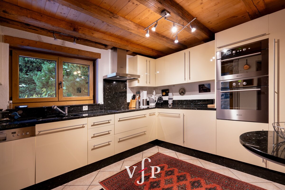 A kitchen with white cabinets and black granite counter tops