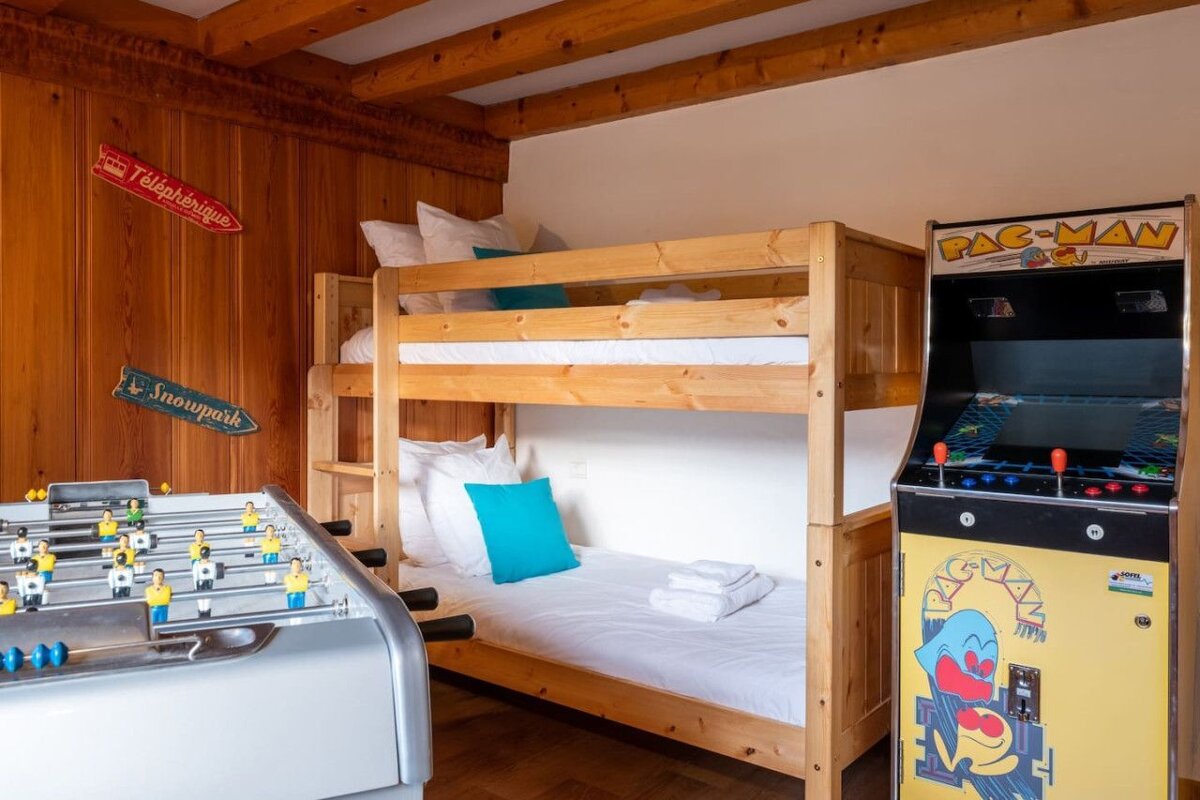 A bunk bed next to a pac-man arcade game