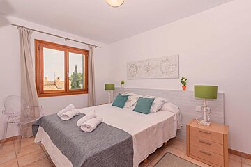 A bedroom with a large bed and two lamps