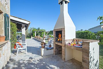 A patio with a bbq and a white chair