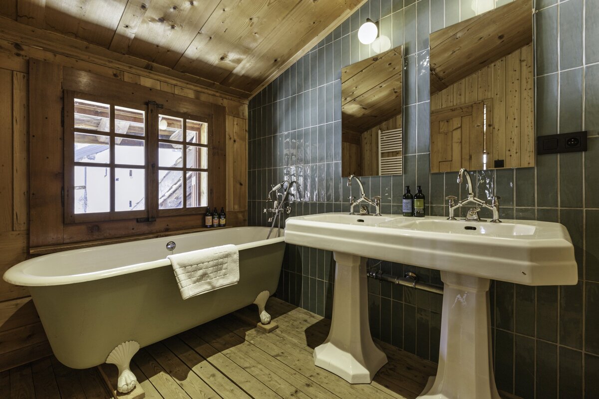 A bathroom with a claw foot tub and two sinks
