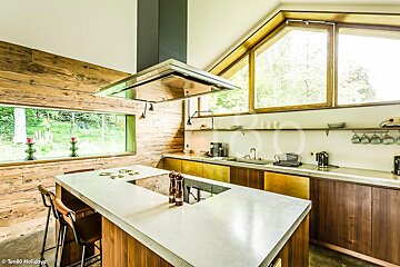 A kitchen with wooden cabinets and a large island