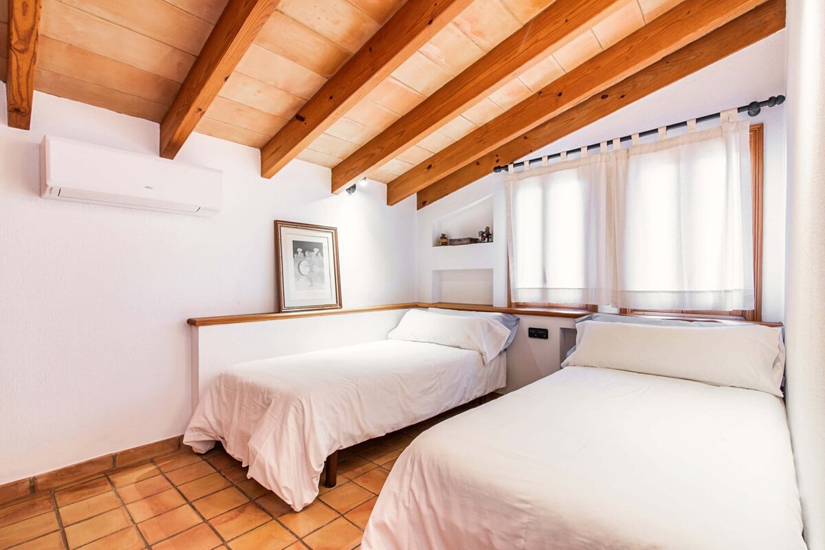 A bedroom with two beds and a picture on the wall