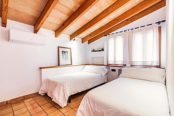 A bedroom with two beds and a picture on the wall