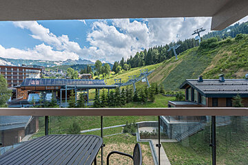 A view of a ski lift from a balcony with a table and chairs