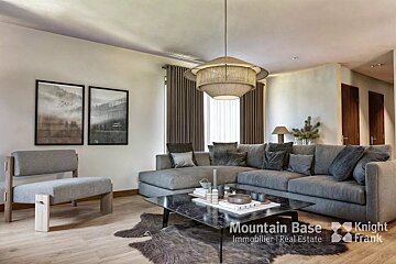 A living room with a large sectional couch and a coffee table from mountain base