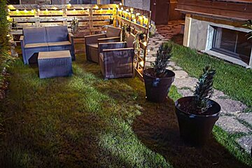 A lawn with a couch and chairs and potted plants