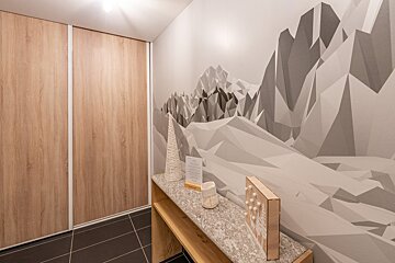 A room with a painting of mountains on the wall