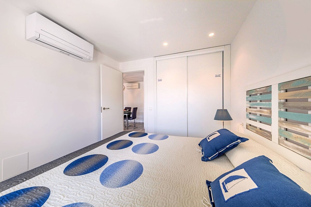 A bedroom with a blue and white blanket and pillows