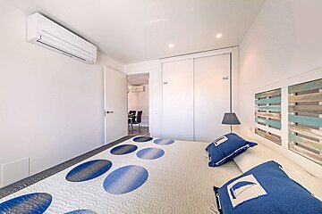 A bedroom with a blue and white blanket and pillows