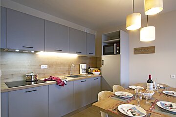 A bottle of wine sits on a table in a kitchen