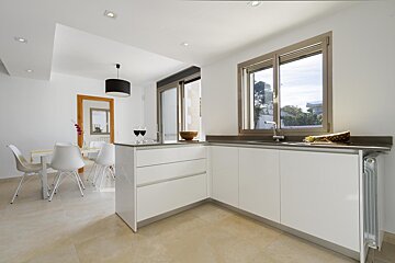 A kitchen with white cabinets and a large window