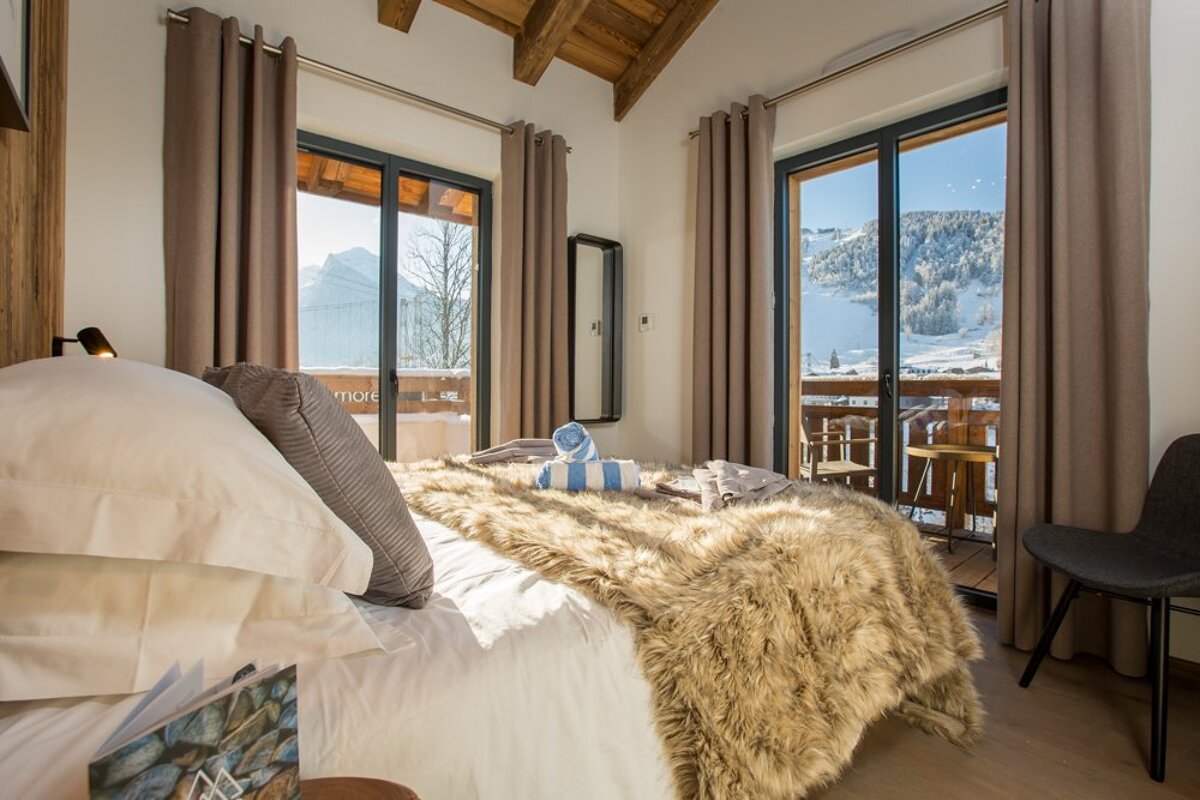 A bedroom with a sliding glass door leading to a balcony