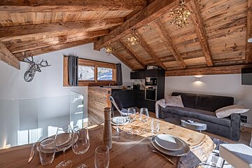 A kitchen with a wooden table and a bottle of wine