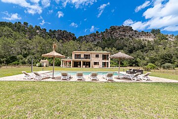 A large house with a swimming pool in front of it