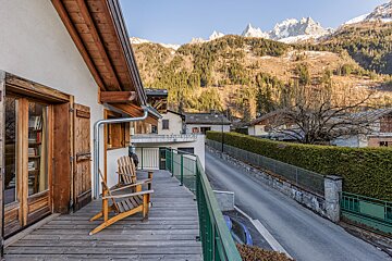 A balcony with chairs and a view of mountains