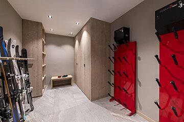 A closet filled with skis and a red rack that says parallax