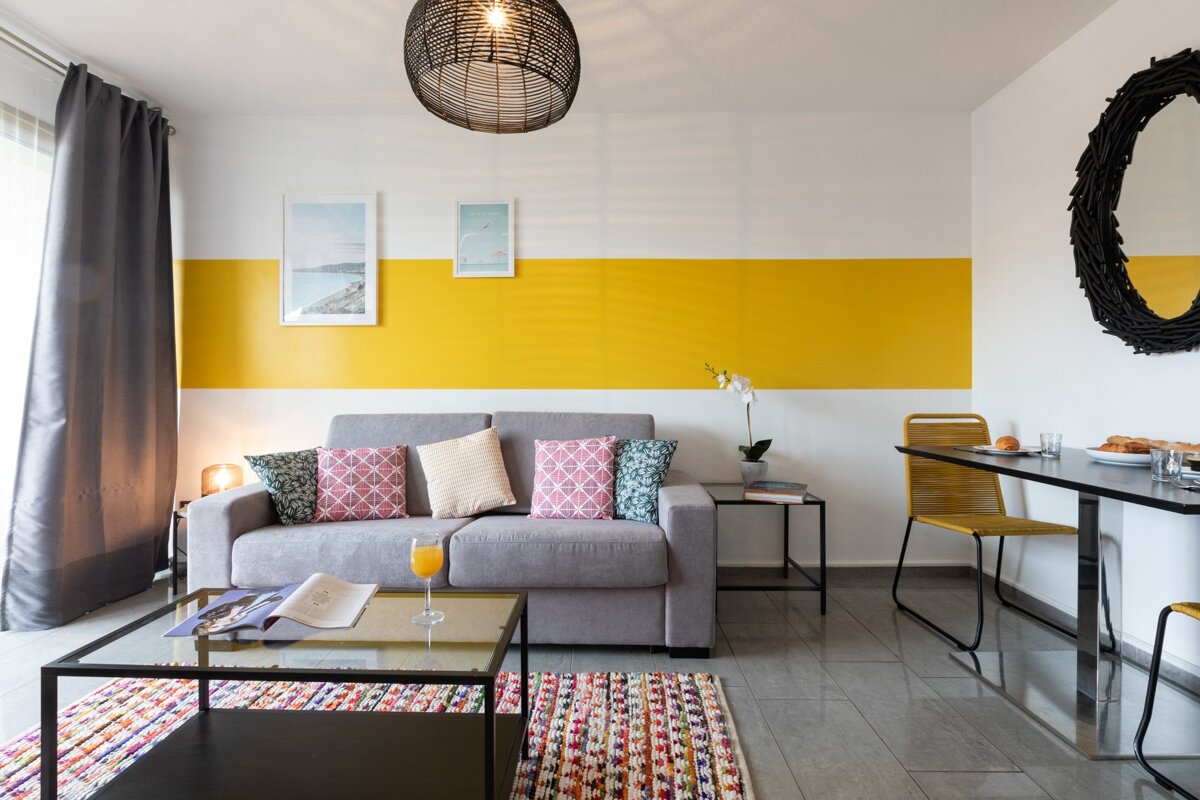 A living room with a yellow and white stripe on the wall